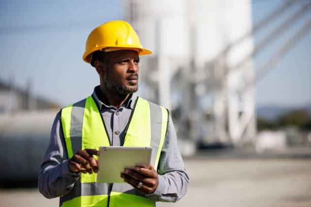 Portrait of male engineer with hardhat using digital tablet while working on his work site